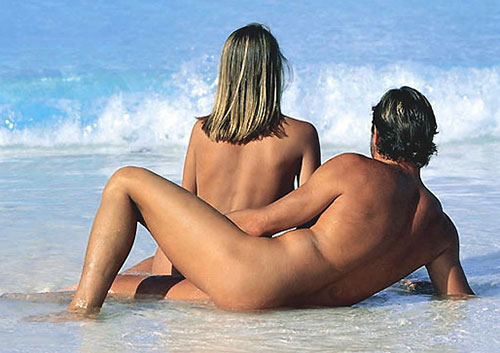 Couple naked sitting on beach